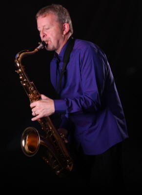 Solo saxophonist Mike Sax player wearing a blue shirt. He plays in Lancashire, Merseyside and Derbys
