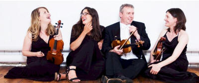 The NC String Quartet Laughing quartet holding their instruments. They play in Durham