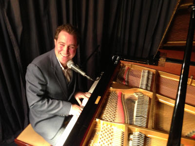 Pianist & Singer - Joss Smiling pianist in lounge suit. He plays in Sussex and Kent